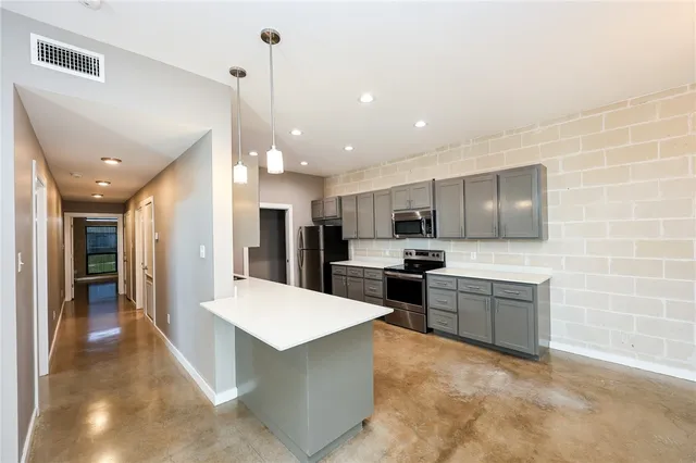 a large kitchen with kitchen island a sink stainless steel appliances and cabinets
