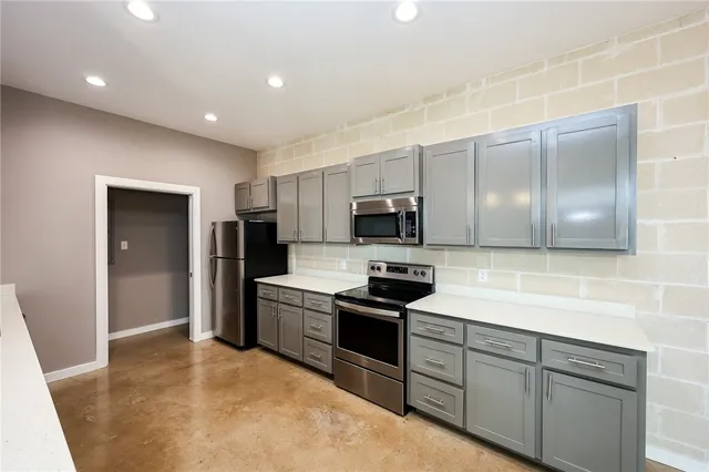 a kitchen with stainless steel appliances granite countertop a stove a sink and a refrigerator