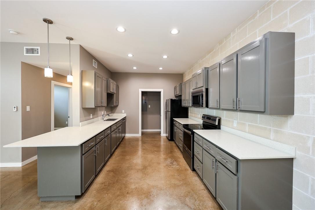 306 Easy Street, Unit A Corpus Christi, TX 78418 - Photo 9 of 22 a large kitchen with stainless steel appliances lots of counter space and wooden floor