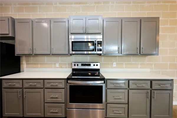 a kitchen with granite countertop a sink stove and microwave