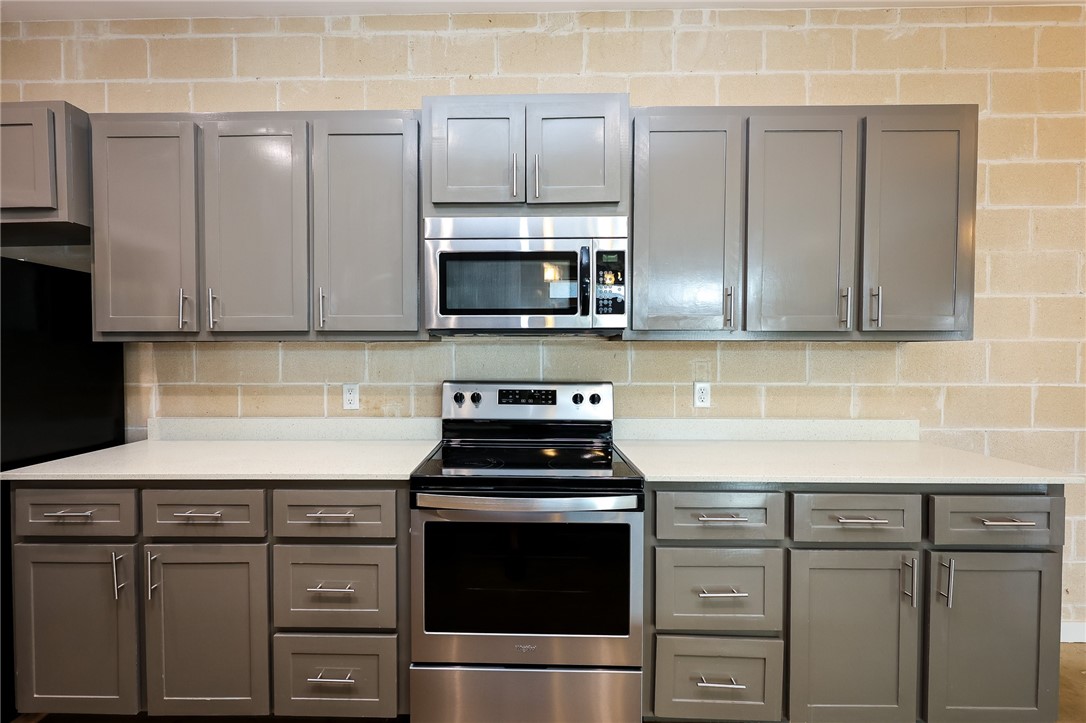 306 Easy Street, Unit A Corpus Christi, TX 78418 - Photo 10 of 22 a kitchen with granite countertop a sink stove and microwave