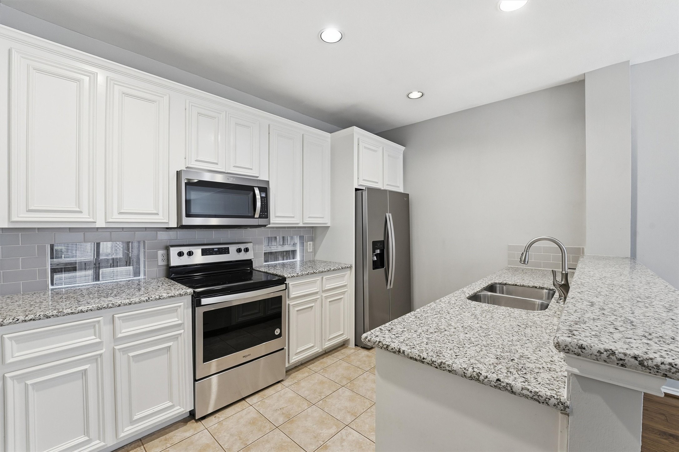 1507 Sutton Street Houston, TX 77006 - Photo 7 of 31 a kitchen with granite countertop a sink stainless steel appliances and white cabinets