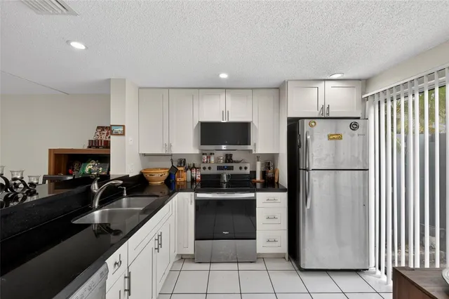 a kitchen with granite countertop a refrigerator and a sink
