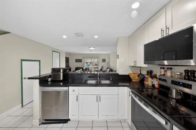 a kitchen with stainless steel appliances granite countertop a sink and a stove