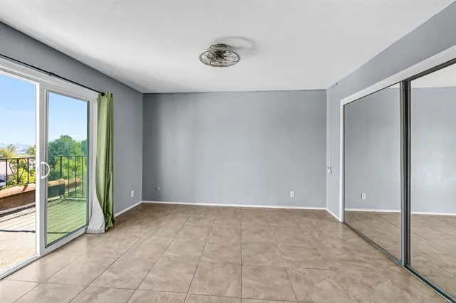 an empty room with sliding door and balcony view