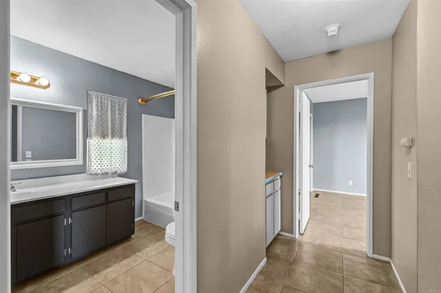 a bathroom with a sink a toilet and a large mirror