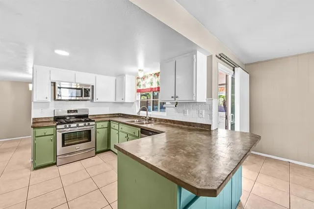 a kitchen with kitchen island granite countertop a stove sink and cabinets