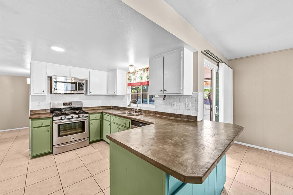 735 South Upas Street Escondido, CA 92025 - Photo 7 of 28 a kitchen with kitchen island granite countertop a stove sink and cabinets