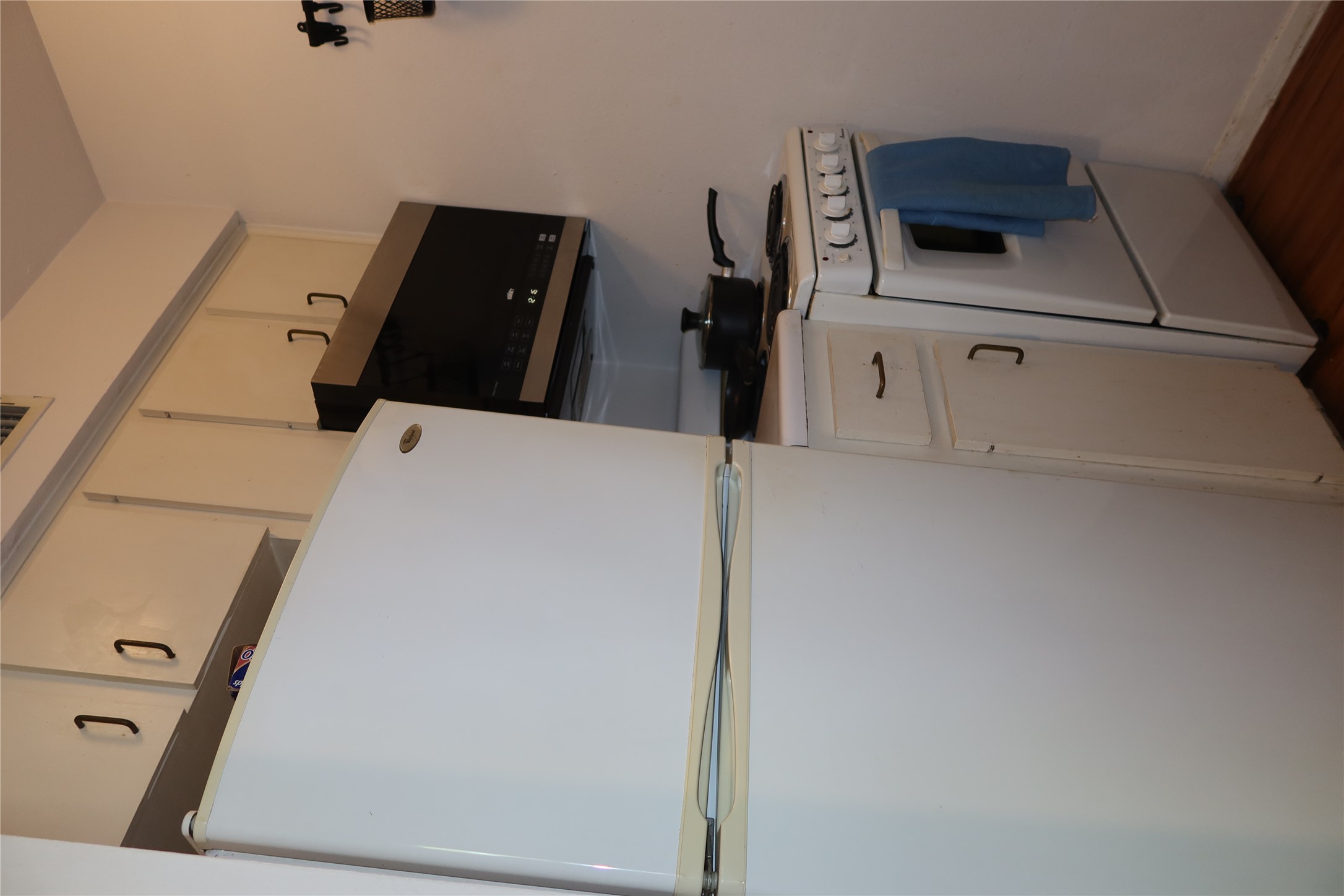 3400 Speedway, Unit 104 Austin, TX 78705 - Photo 11 of 23 Kitchen with white appliances, dark wood-style flooring, light countertops, and white cabinets