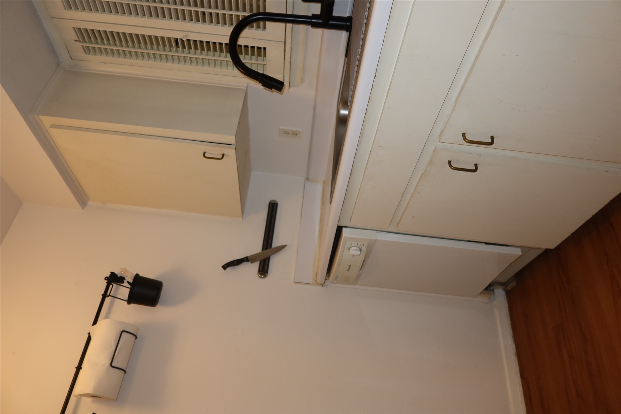 3400 Speedway, Unit 104 Austin, TX 78705 - Photo 10 of 23 Kitchen featuring dark wood-style floors, white dishwasher, light countertops, and white cabinets