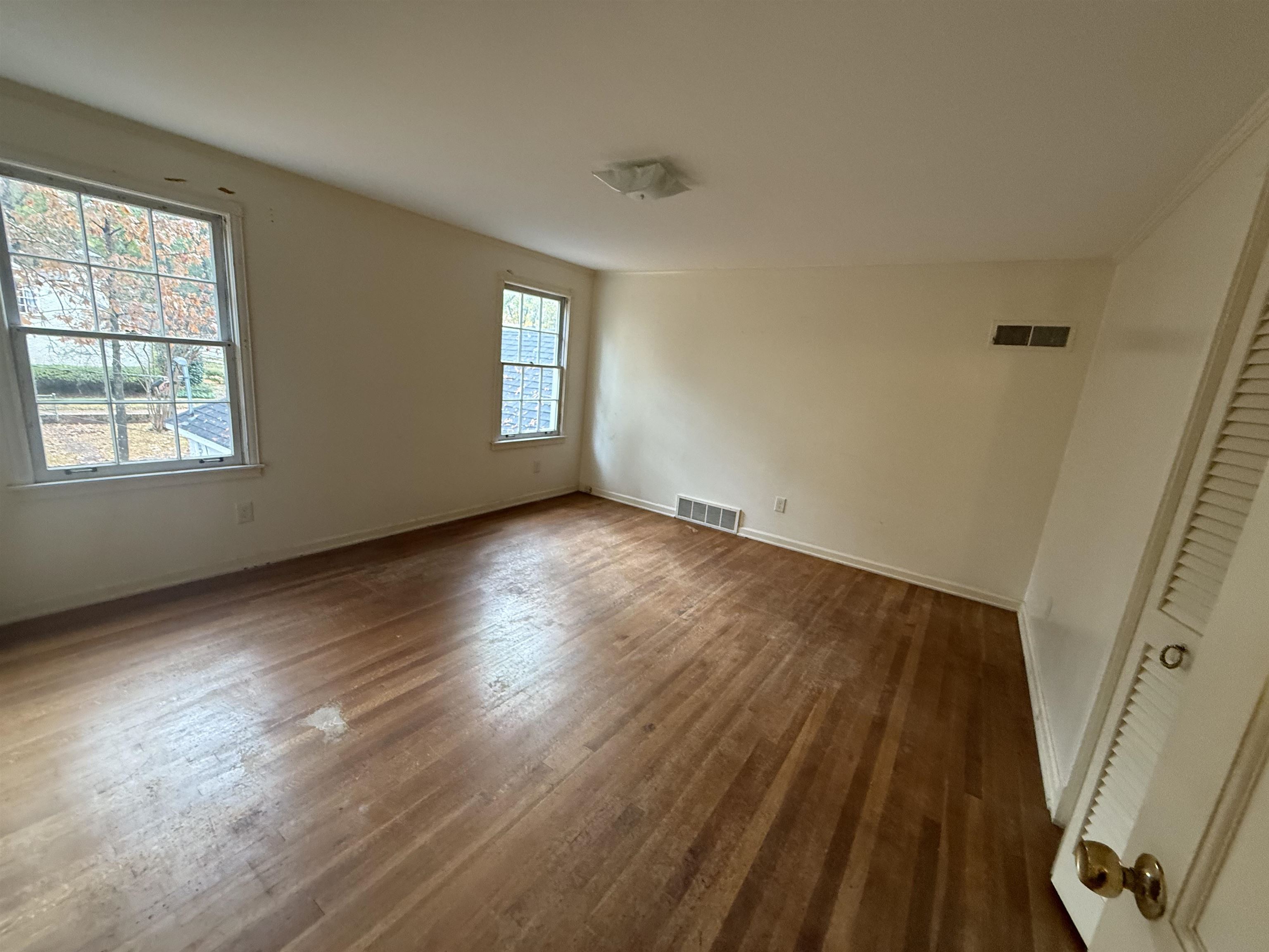 5575 Walnut Grove Road Memphis, TN 38120 - Photo 33 of 36 a view of an empty room with wooden floor and a window