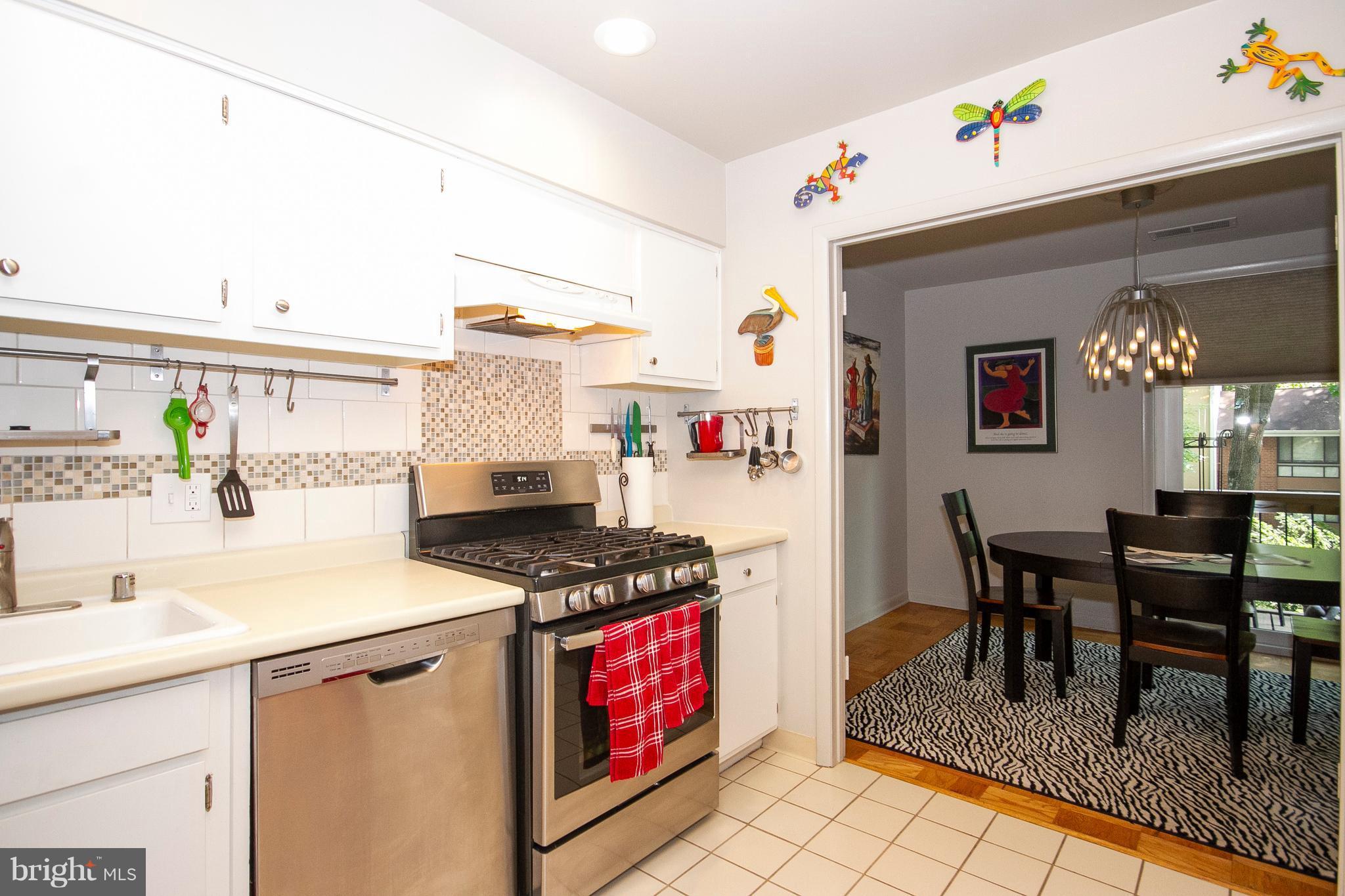 14 Cross Keys Road, Unit 14D Baltimore, MD 21210 - Photo 8 of 25 a kitchen with granite countertop a stove a sink and a dining table