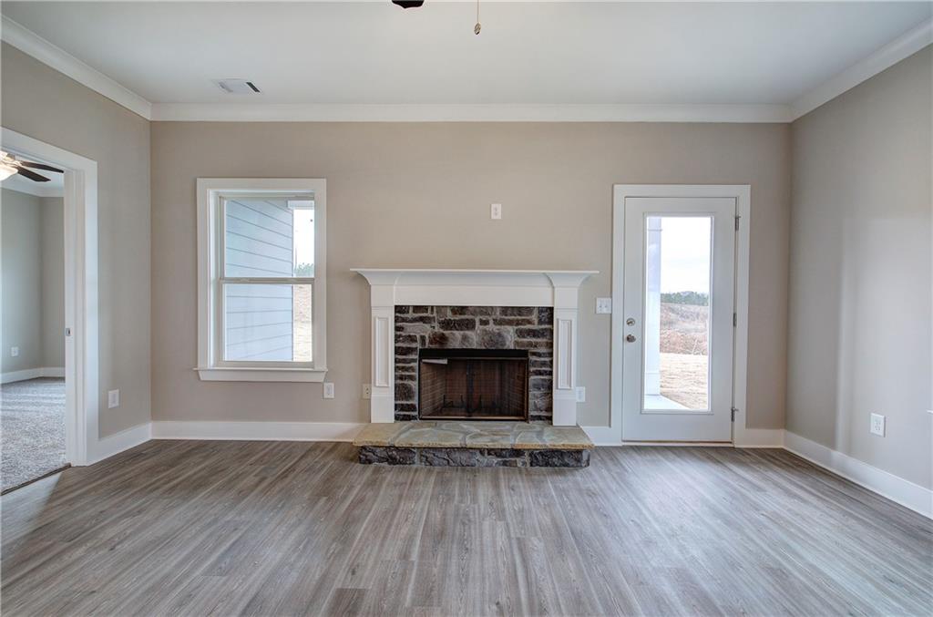 201 Daisy Court Cartersville, GA 30121 - Photo 17 of 36 an empty room with wooden floor fireplace and windows