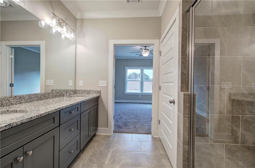 201 Daisy Court Cartersville, GA 30121 - Photo 24 of 36 a bathroom with a granite countertop sink a mirror and a shower