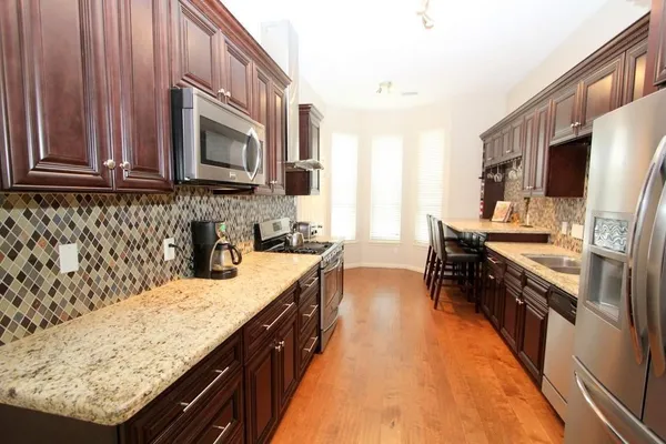 a kitchen with stainless steel appliances granite countertop a sink stove and refrigerator