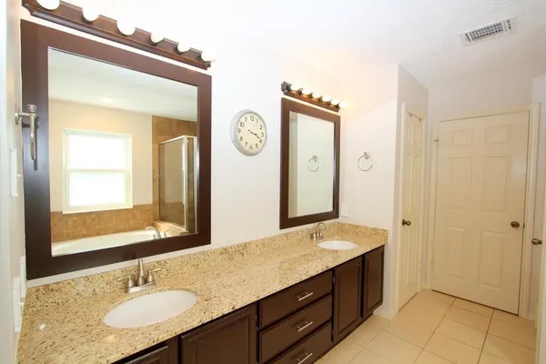 a bathroom with a granite countertop sink and a mirror