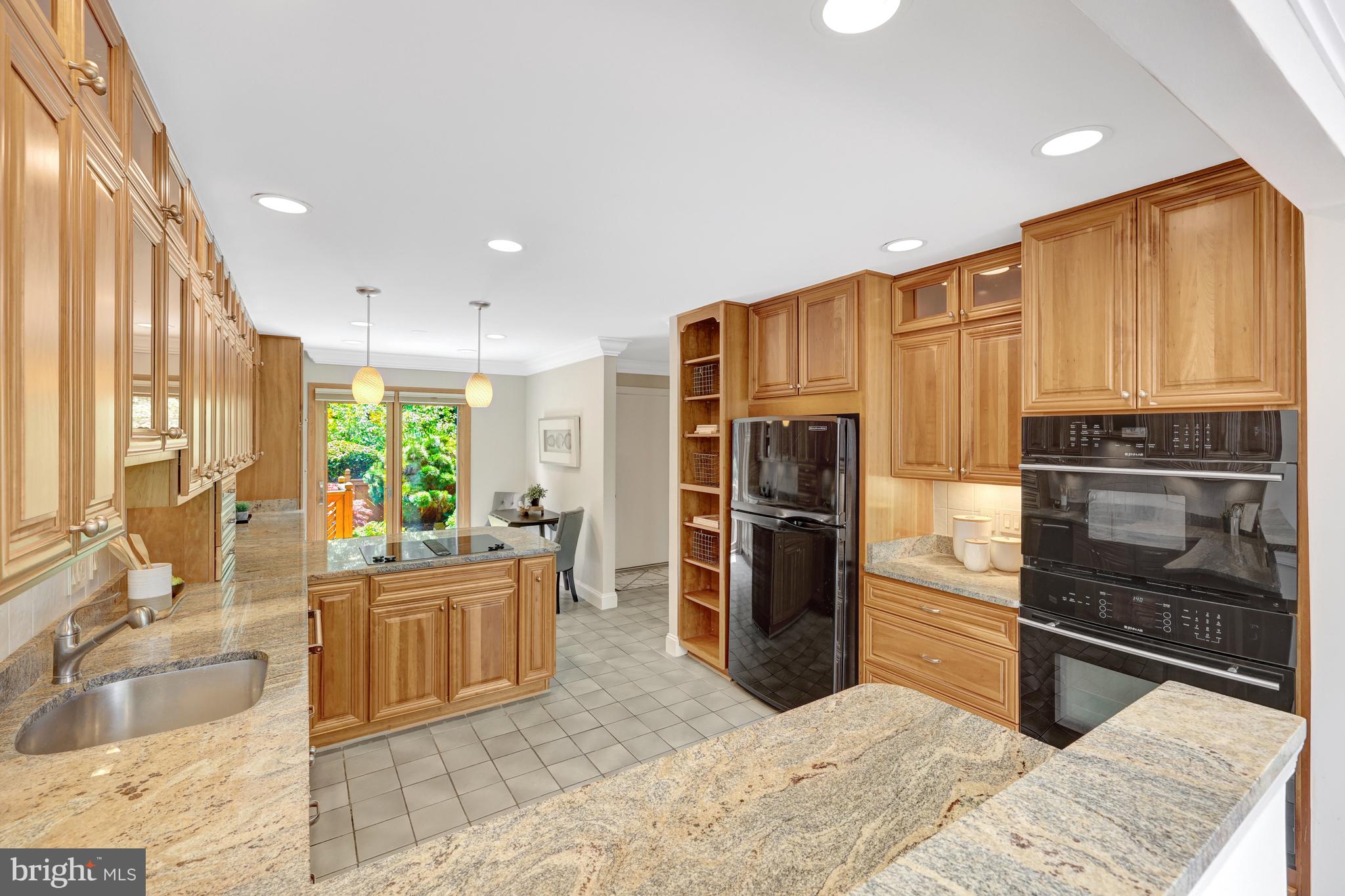 11064 Thrush Ridge Road Reston, VA 20191 - Photo 16 of 85 a kitchen with stainless steel appliances kitchen island granite countertop a refrigerator and a sink