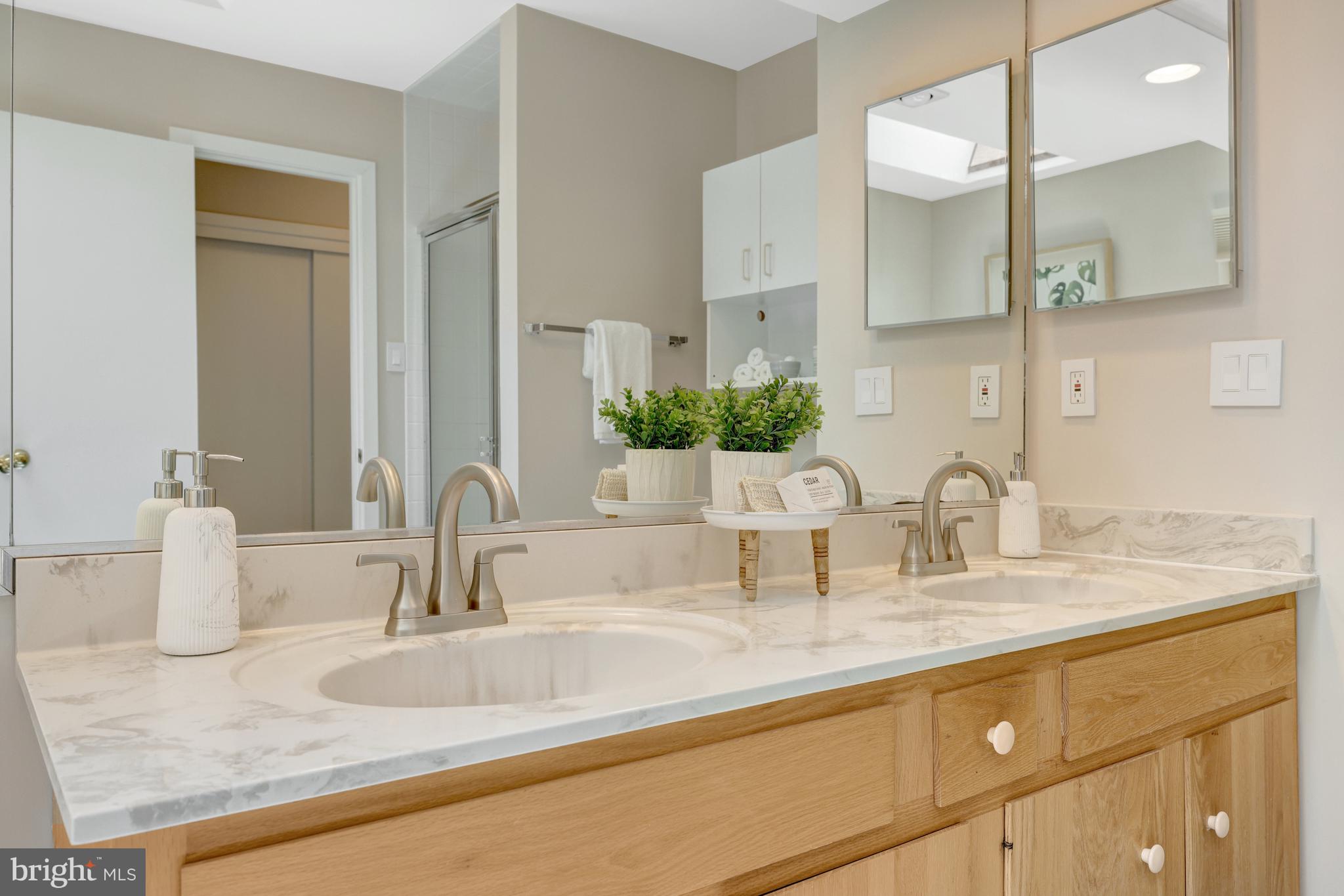 11064 Thrush Ridge Road Reston, VA 20191 - Photo 44 of 85 a bathroom with double vanity sinks granite vanity and a mirror
