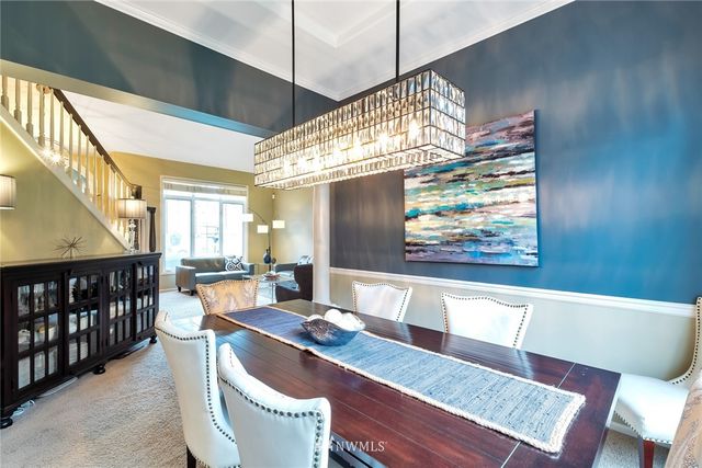 a view of a dining room with furniture a chandelier and wooden floor
