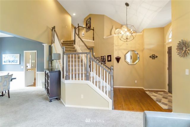 a view of a hallway with a dining table chairs