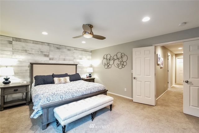 a bedroom with a large bed and a chandelier