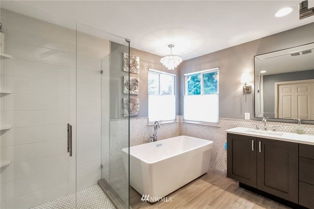 a spacious bathroom with a double vanity sink a mirror and a bathtub