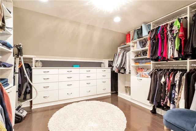a view of walk in closet with clothes and shoes