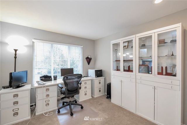 a view of a workspace with furniture and a window