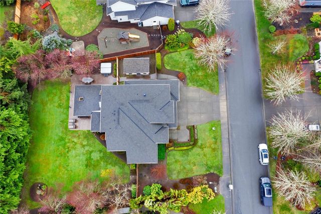 an aerial view of a house with a yard and a large pool