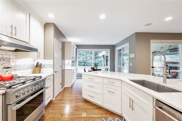 a kitchen with granite countertop a sink stainless steel appliances and cabinets