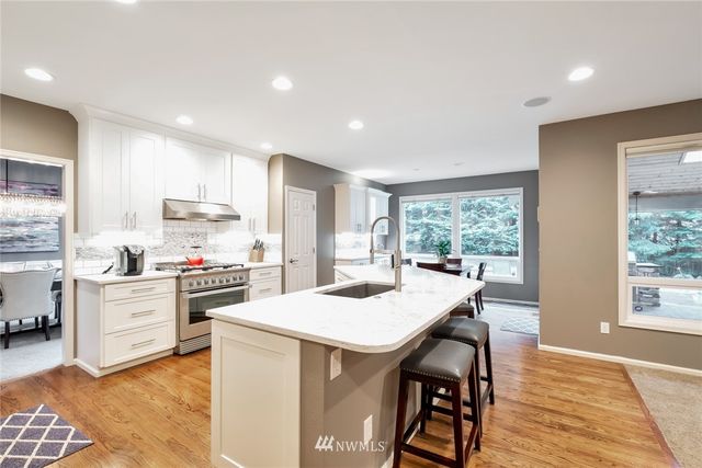 a kitchen with a table chairs stove and cabinets
