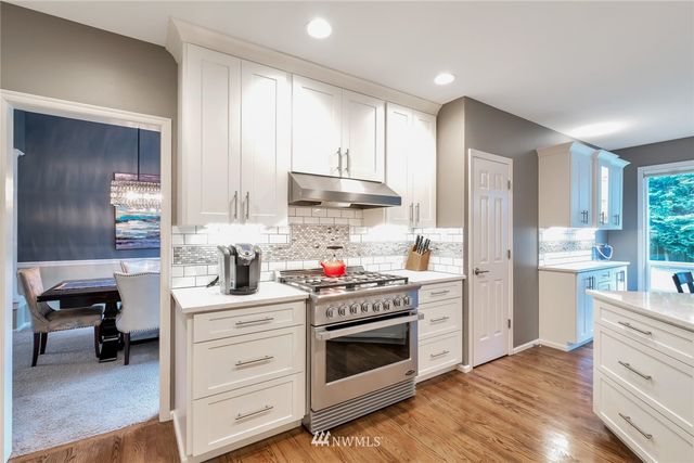 a kitchen with stainless steel appliances white cabinets and a refrigerator