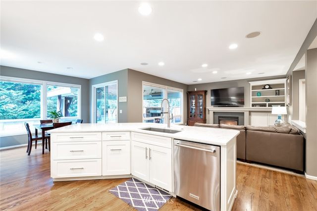 a kitchen with stainless steel appliances white cabinets and wooden floors