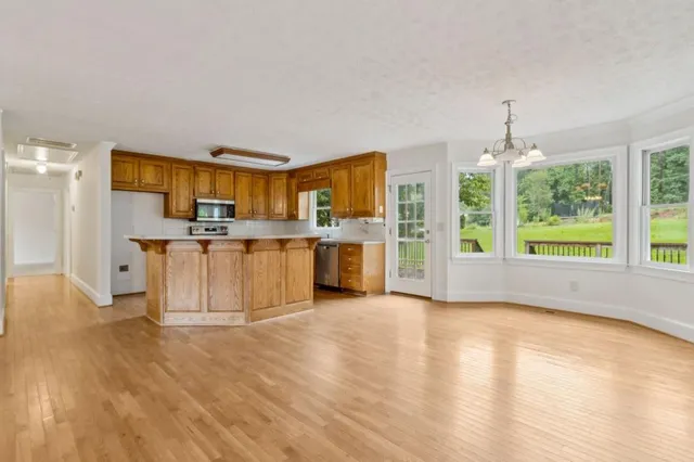 a view of a kitchen with furniture and wooden floor