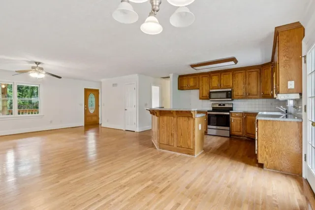 a kitchen with stainless steel appliances wooden floors and wooden cabinets