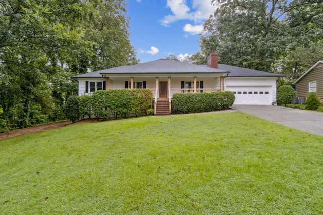 a front view of a house with yard and green space