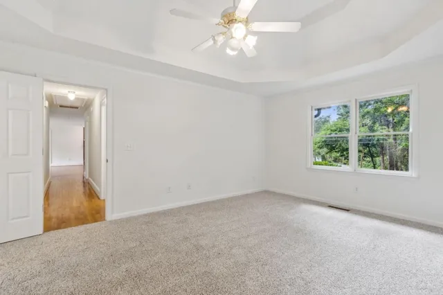 an empty room with windows and fan