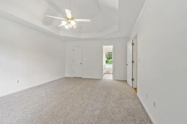 an empty room with closet and a ceiling fan