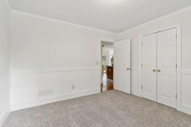 an empty room with wooden floor and window