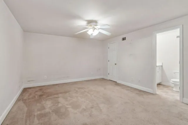 a view of an empty room with a chandelier fan
