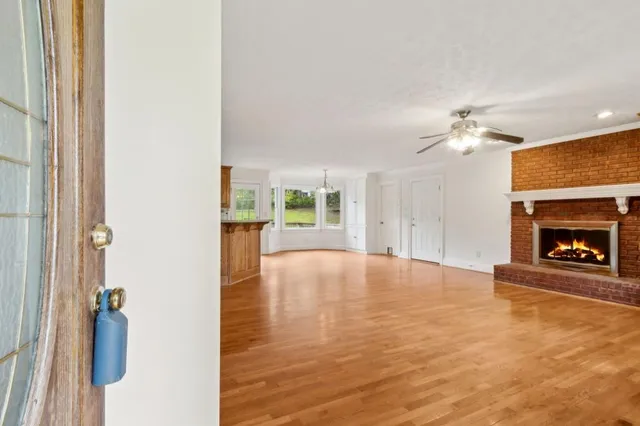 a view of an empty room with a fireplace and a window
