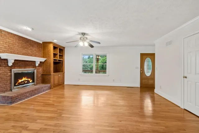 a view of an empty room with a fireplace and a window