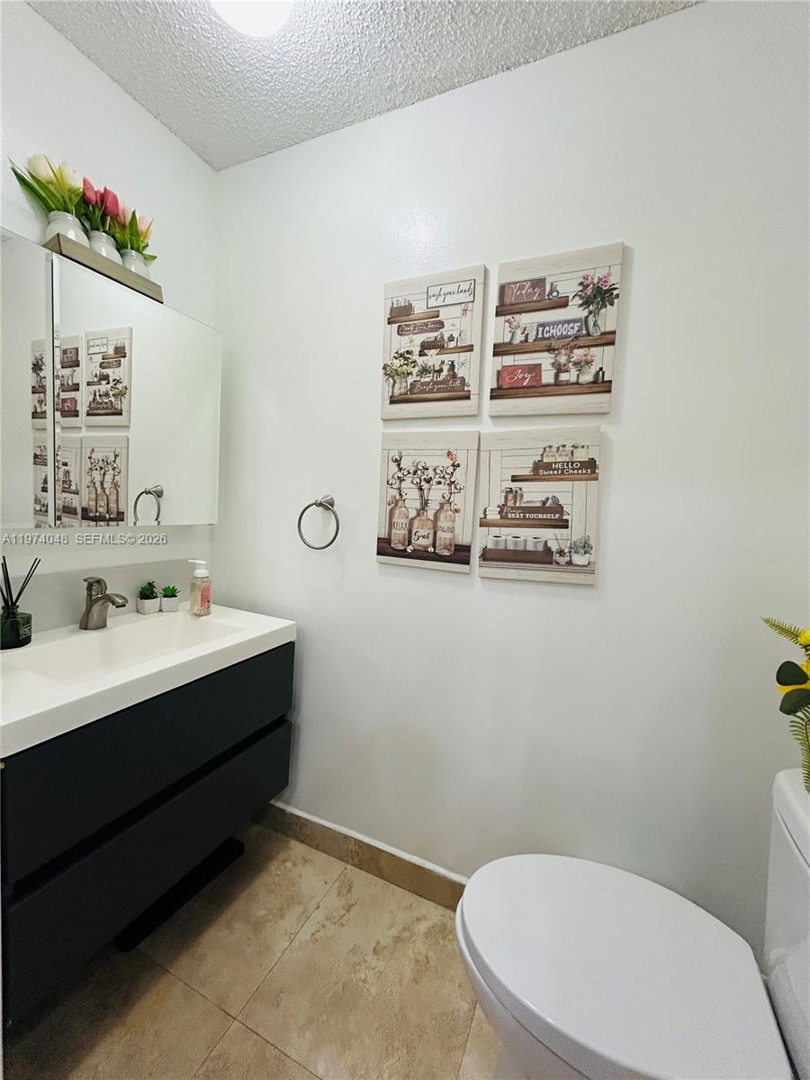 13890 Southwest 64th Street Miami, FL 33183 - Photo 15 of 23 a bathroom with a toilet sink and mirror