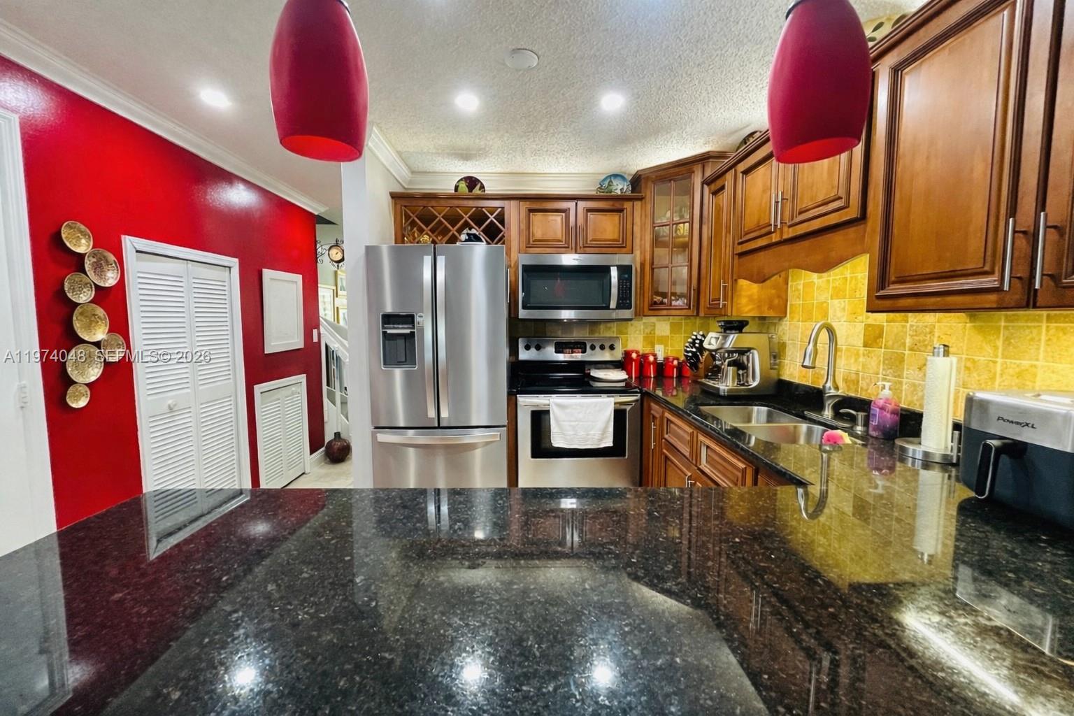 13890 Southwest 64th Street Miami, FL 33183 - Photo 9 of 23 a kitchen with stainless steel appliances granite countertop a refrigerator a stove and a sink
