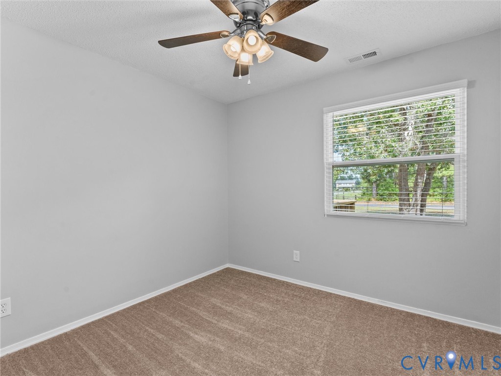 6927 Carsley Road Waverly, VA 23890 - Photo 18 of 51 Neutral paint palette, ceiling fan with light fixt