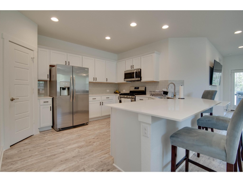 a kitchen with stainless steel appliances a refrigerator sink and microwave