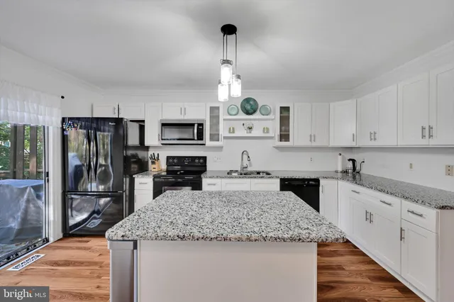 a kitchen with granite countertop kitchen island cabinets stainless steel appliances and a counter space