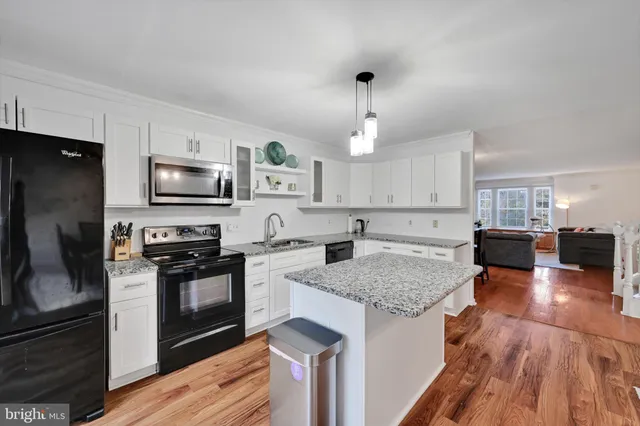 a kitchen with a center island appliances and cabinets