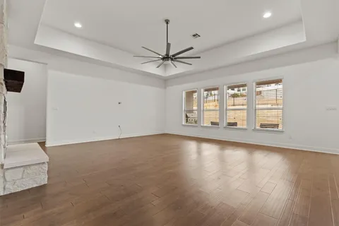 an empty room with windows and ceiling fan