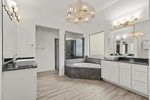 a spacious bathroom with a double vanity sink a mirror and a shower